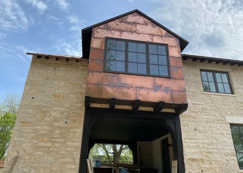 Copper metal panel facade on a stone building for Skylight Installation in Jennings