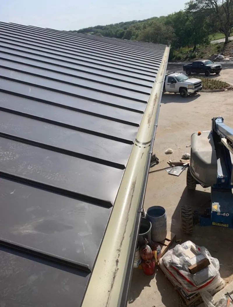 Standing seam panel and gutter detail on a metal roofing jobsite in Jennings